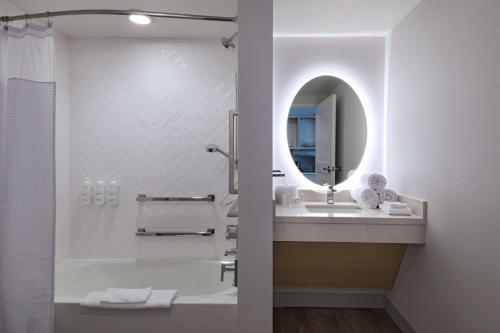 a bathroom with a tub and a sink and a mirror at TownePlace Suites by Marriott Brentwood in Brentwood