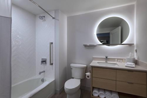 a bathroom with a toilet and a sink and a mirror at TownePlace Suites by Marriott Brentwood in Brentwood