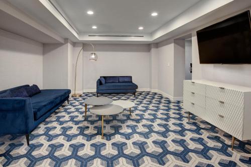 a living room with a couch and a tv and a table at Sheraton Eatontown Hotel in Eatontown