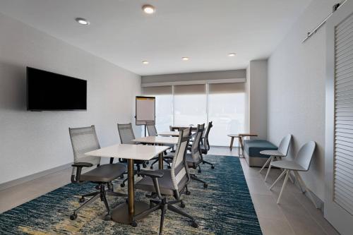 a conference room with tables and chairs and a flat screen tv at TownePlace Suites by Marriott Brentwood in Brentwood