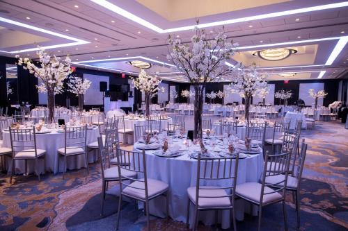 a banquet hall with white tables and chairs at Sheraton Eatontown Hotel in Eatontown