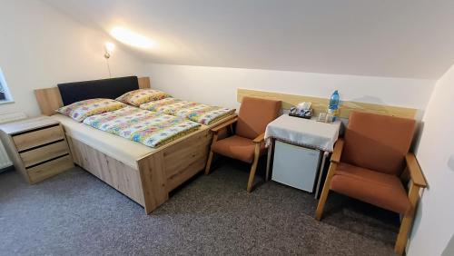 a small room with a bed and two chairs at Pension 444 - Ski Resort Herlikovice and Bubakov in Vrchlabí