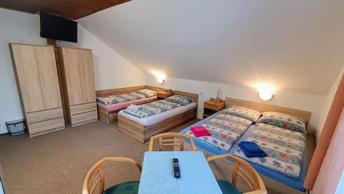 a room with three beds and a table and chairs at Pension 444 - Ski Resort Herlikovice and Bubakov in Vrchlabí