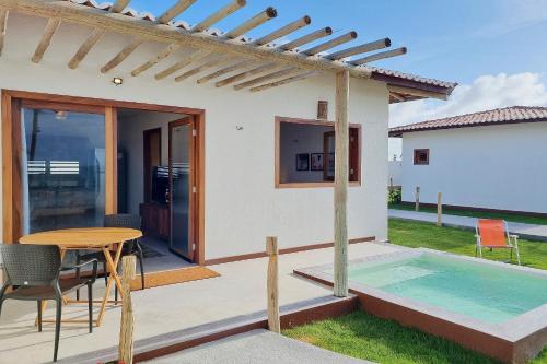 a patio with a table and a swimming pool at The Point Bangalô Pé na Areia em Fortim in Fortim