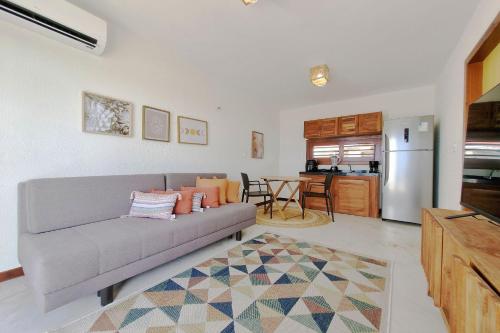 a living room with a couch and a kitchen at The Point Bangalô Pé na Areia em Fortim in Fortim
