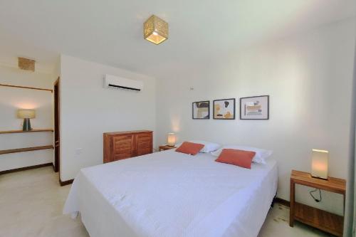 a white bedroom with a white bed and two lamps at The Point Bangalô Pé na Areia em Fortim in Fortim
