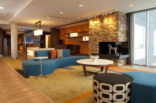 a lobby with a blue couch and a fireplace at Fairfield Inn & Suites by Marriott Lethbridge in Lethbridge