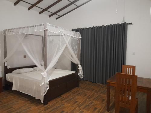 a bedroom with a bed with a canopy at Villa Tanzanite in Tangalle