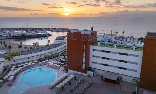 a view of a resort with a pool and the ocean at AluaSoul Costa Adeje - Adults Only in Adeje