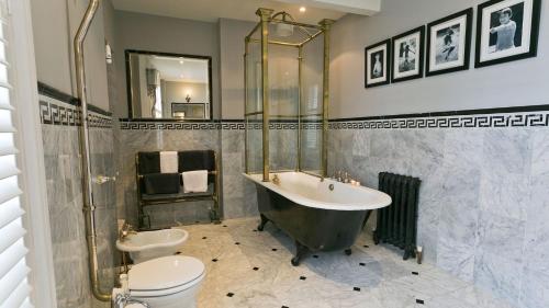 a bathroom with a tub and a toilet and a sink at Bay House in Beaumaris