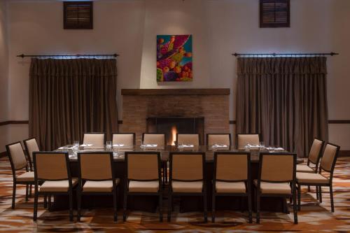 a long table in a room with chairs and a fireplace at La Posada De Santa Fe, a Tribute Portfolio Resort & Spa in Santa Fe
