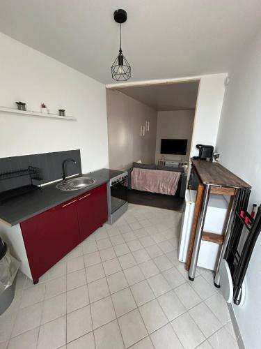 une cuisine avec un évier et une chambre avec un lit dans l'établissement Studio indépendant, à Saint-Éloi