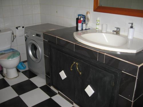 a bathroom with a sink and a washing machine at KEUR MARIE FAYE in Mbour