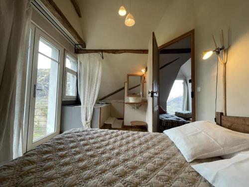 Un dormitorio con una cama grande y una ventana grande en Uthurraltia, en Larrau