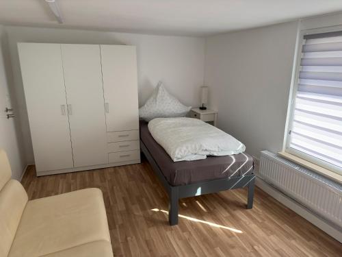 a bedroom with a bed and a white cabinet at Monteurzimmer bei Jena - T und T GbR in Bucha