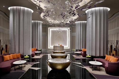 a lobby with purple chairs and a large chandelier at The St. Regis Amman in Amman