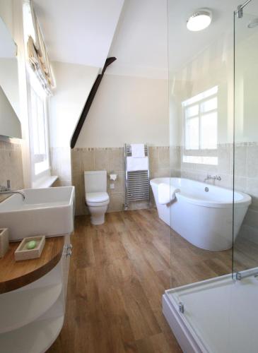 a bathroom with a tub and a toilet and a sink at Ilsington Country House Hotel & Spa in Ilsington