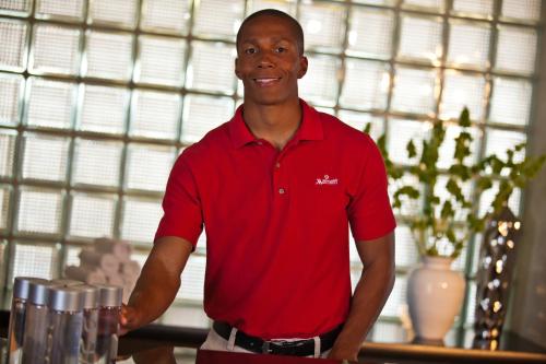 a man in a red shirt standing next to a counter at Kansas City Marriott Downtown in Kansas City