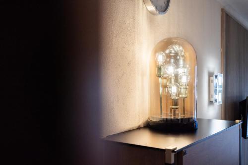 a glass clock on a shelf in a room at Das Solaris 1 Beach Apartment mit Balkon, hundefreundlich und modern in Grömitz