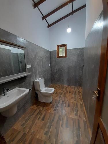 a bathroom with a white toilet and a sink at Villa Tanzanite in Tangalle