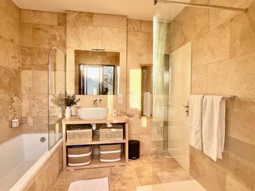 une salle de bain avec un lavabo, une douche et une baignoire dans l'établissement Les Terres Rouges du Salagou, à Le Bosc