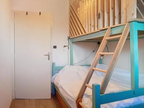 Ce lit superposé se trouve dans un dortoir avec une échelle. dans l'établissement Charmant 2 pièces à Val d'Isère, 4 pers, proche centre, TV, WiFi - FR-1-518-164, à Val dʼIsère