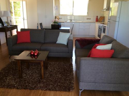 a living room with two couches and a coffee table at Tinaroo Sunset Retreat in Barrine