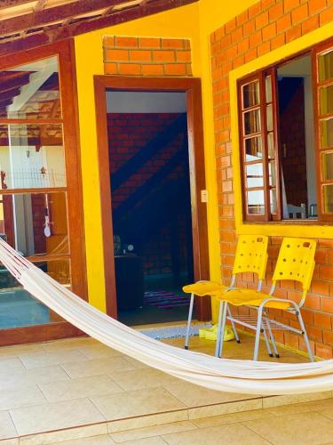 a hammock in front of a house with a building at Hostel Ribeirão do Sol in Florianópolis
