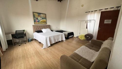 a living room with a bed and a couch at Hostel Ribeirão do Sol in Florianópolis