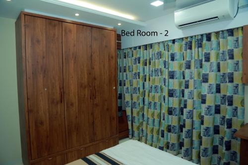 a room with a wooden door and a curtain at Asset Chrisaballe in Kottayam