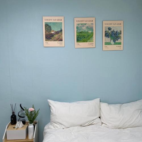a bed with four posters on a blue wall at Sky Garden in Seoul