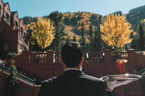 a man in a suit holding a plate of food at St. Regis Aspen Resort in Aspen