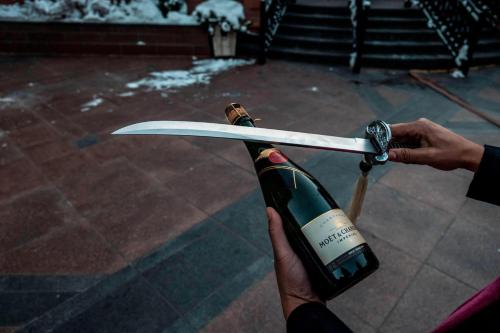 a person holding a wine bottle and a surfboard at St. Regis Aspen Resort in Aspen