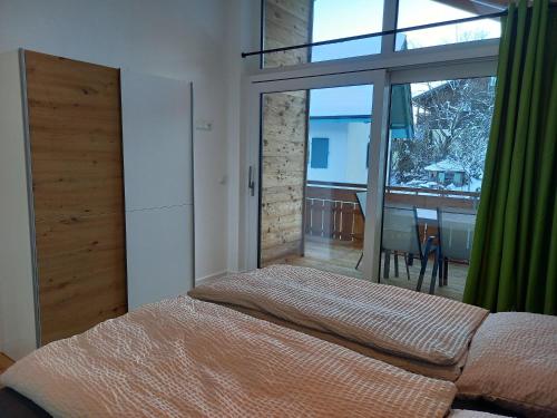a bedroom with a bed and a large window at Bergzauber Ofterschwang in Ofterschwang