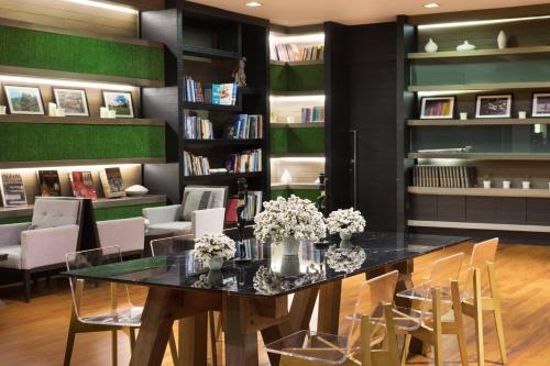 a library with a table with flowers and chairs at Le Meridien Chiang Rai Resort, Thailand in Chiang Rai
