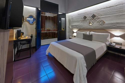 a hotel room with a large bed and a desk at City Centro by Marriott Ciudad de Mexico in Mexico City