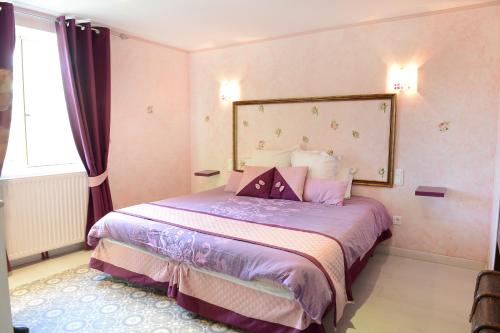 a bedroom with a bed with purple sheets and a window at lO GORISSADO - La ferme du glandier in Saint-André-dʼAllas