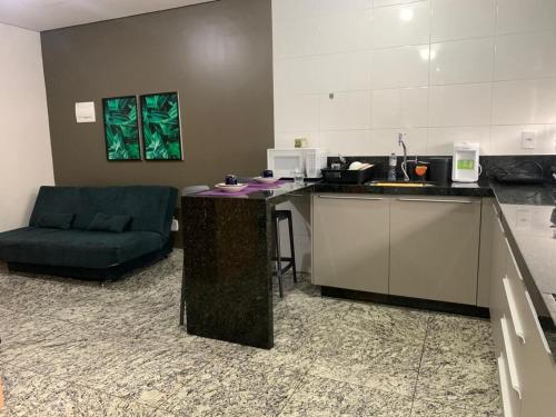a kitchen with a counter and a couch in a room at LK Lourdes 7 in Belo Horizonte