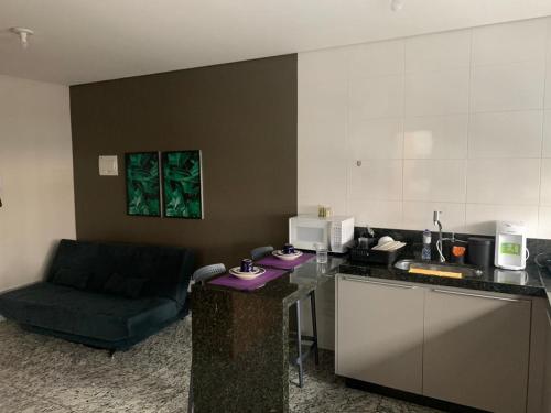 a kitchen with a counter and a chair in a room at LK Lourdes 7 in Belo Horizonte