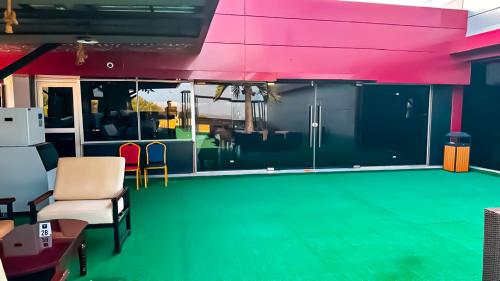 a living room with a green floor and pink ceilings at Tribu Hotels in Enugu