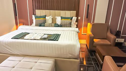 a hotel room with a bed and a chair at Tribu Hotels in Enugu