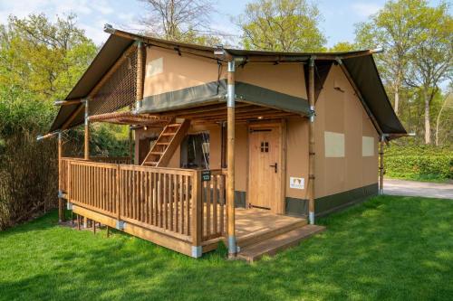 a small house with a porch and a deck at Glamping Rhederlaagse Meren in Lathum