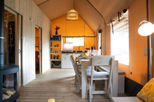 eine Küche und ein Esszimmer mit Tisch und Stühlen in der Unterkunft Glamping Rhederlaagse Meren in Lathum
