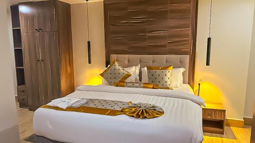 a bedroom with a large white bed with a headboard at Tribu Hotels in Enugu