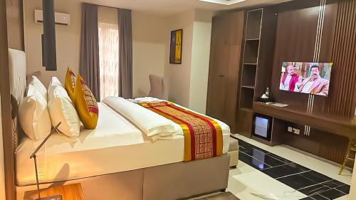 a room with a bed and a television in it at Tribu Hotels in Enugu
