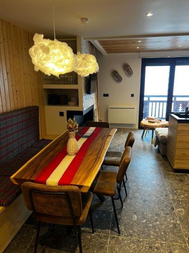 un salon avec une table et des chaises en bois dans l'établissement Stunning apartment with breathtaking view!, à Huez