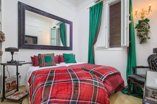 - une chambre dotée d'un lit avec une couverture rouge et verte dans l'établissement Salamanca Luxury Rooms, à Madrid