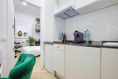 une cuisine avec des armoires blanches et un lit dans une chambre dans l'établissement Salamanca Luxury Rooms, à Madrid