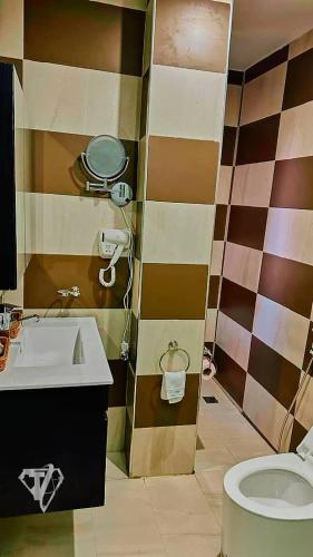 a bathroom with a sink and a toilet at Tribu Hotels in Enugu