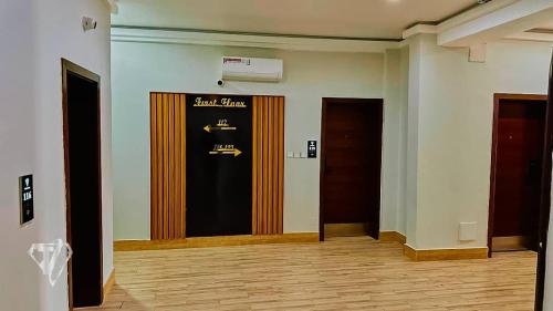 a hallway with two doors and a sign on the wall at Tribu Hotels in Enugu
